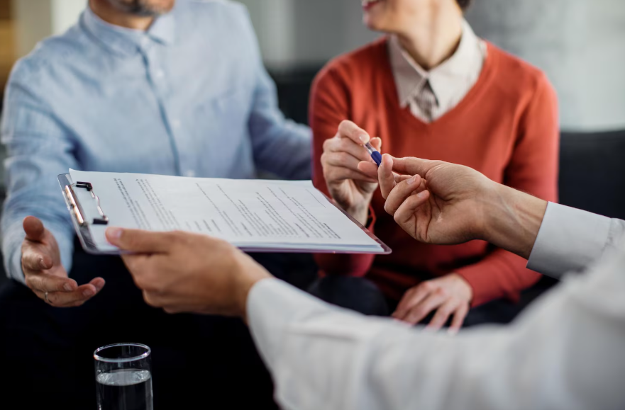 Couple reviewing policy paperwork to decide if insurance loyalty discounts are worth it