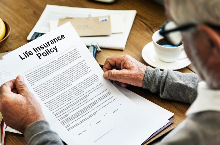 Person reviewing life insurance policy to compare term vs whole vs universal life insurance