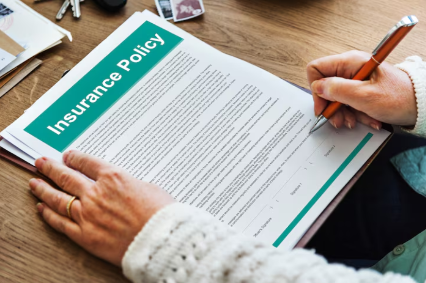 Person reviewing insurance policy document to understand common insurance exclusions