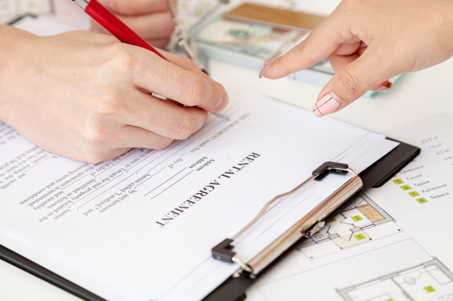 Person signing rental agreement while reviewing what renters insurance covers