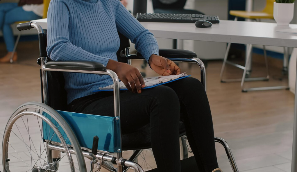 Person in wheelchair reviewing paperwork while learning how disability insurance works