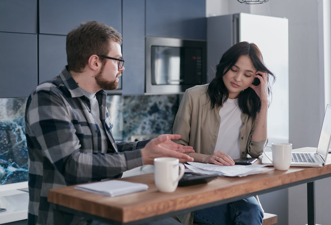 Couple reviewing bills while evaluating bundling insurance policies and household expenses